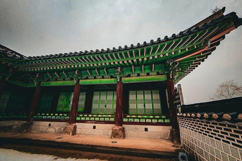 A traditional Korean building with green tiled roofs and wooden columns. 5
