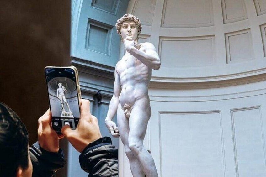 A person taking a photo of a marble statue. 1