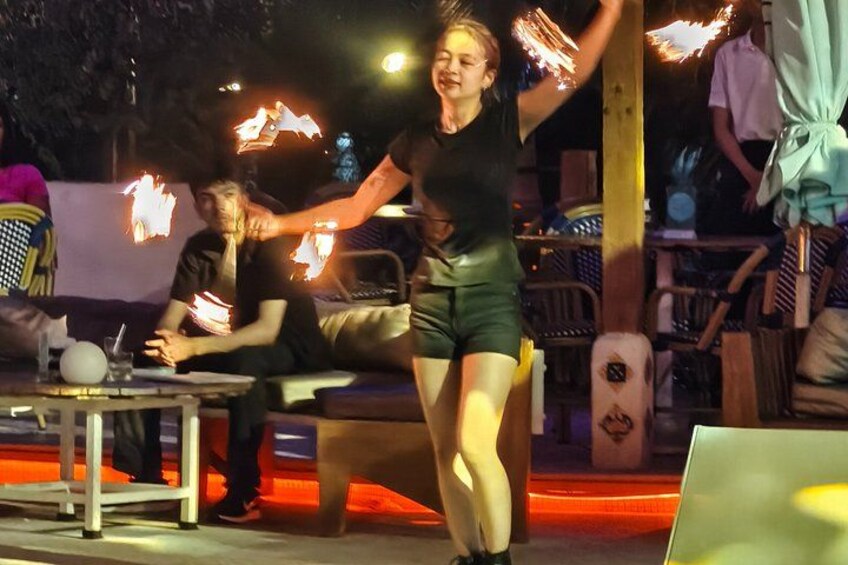 A person performing fire juggling with flaming torches. 4