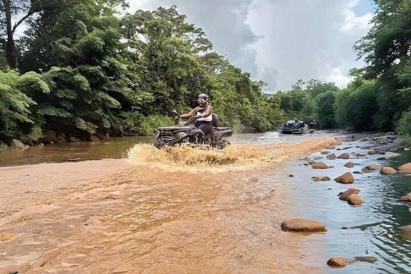 A river with rocks and a vehicle navigating through. 5