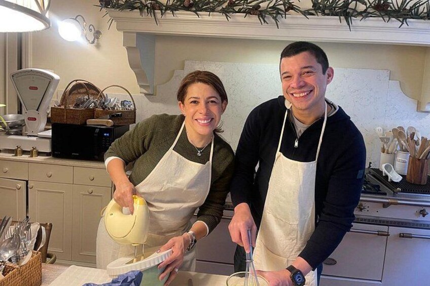 Dos personas en una cocina, una sosteniendo un batidor y la otra un bol. 2