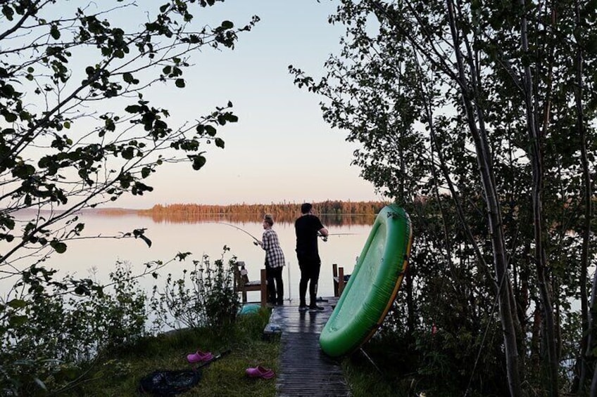Eine Holzstege, der zu einem ruhigen See führt, mit Bäumen an beiden Seiten. 1