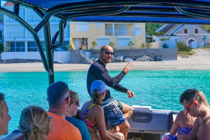 A boat with people on board, a beach, and buildings in the background. 5