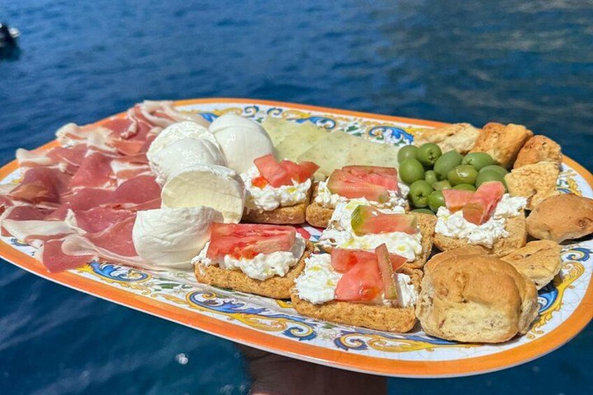 A plate of food with various items including meats, cheese, olives, and bread. 2