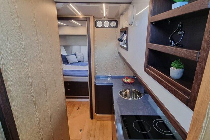 A compact kitchen with a stove, sink, and a small countertop. 5