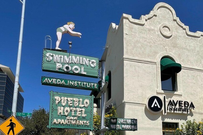 A building with a swimming pool sign, an Aveda Institute sign, and a Puerto Rico Hotel sign. 2