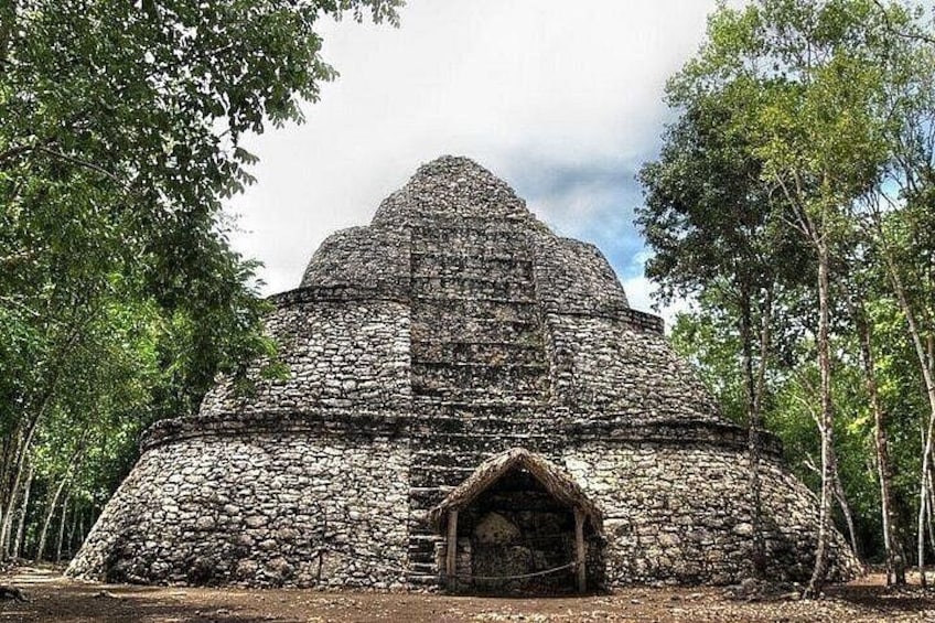 A stone pyramid structure surrounded by trees. 3