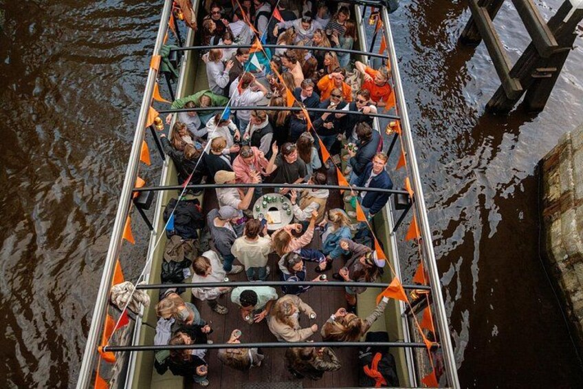 A crowded boat with people seated and standing, surrounded by water. 4