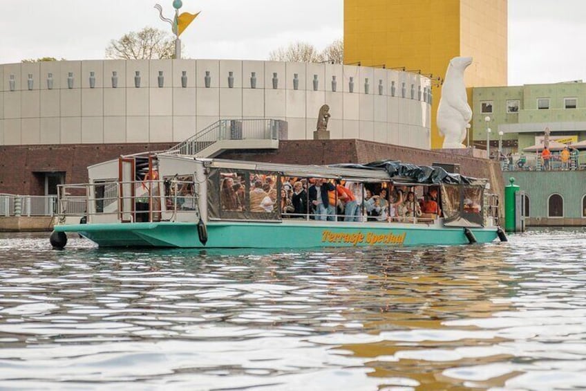 Un bote con gente, un edificio grande con una sección amarilla y una estatua al fondo. 3