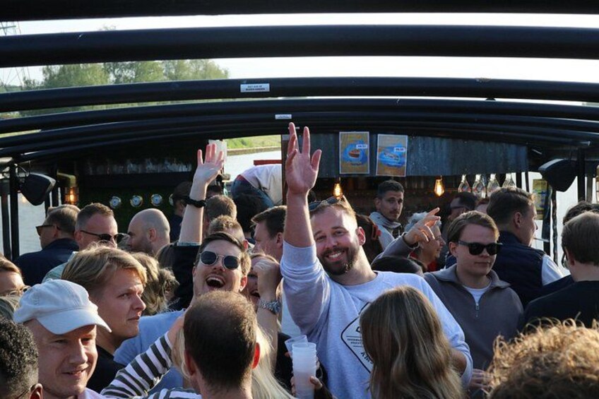 A crowd of people inside a vehicle, some raising their hands. 5
