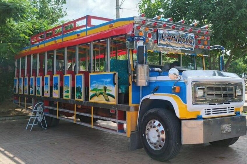 A colorful bus with a 'Caribea' sign, windows, and a ladder. 5