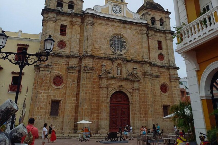 A historic church with a large clock, a red door, and a bell tower. 3