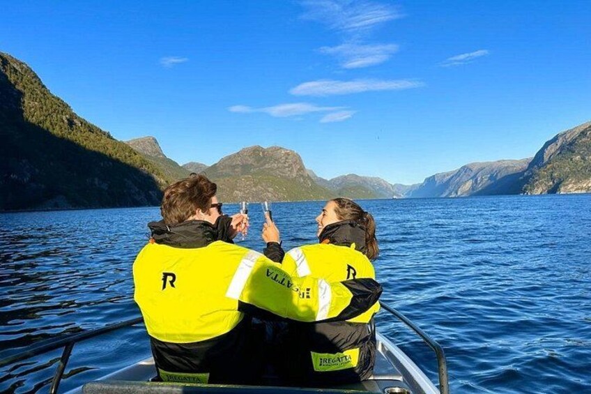 Dos personas con chalecos amarillos en un bote, mirando un teléfono inteligente. 2