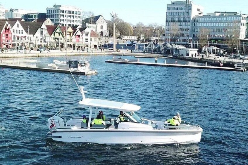 Ein weißes Motorboot mit zwei Personen in Schwimmwesten auf ruhigem Gewässer. 4