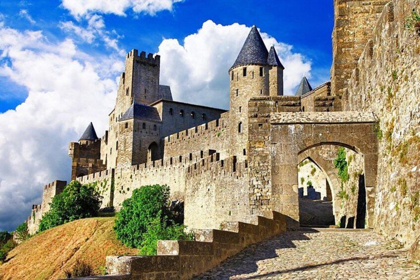 A medieval castle with stone walls, towers, and a stone bridge. 2