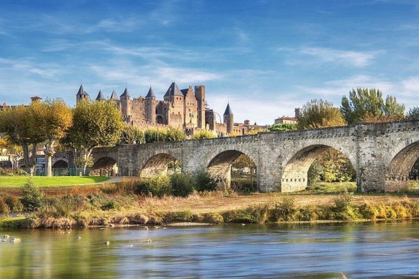 A stone bridge over a river with a castle in the background. 3