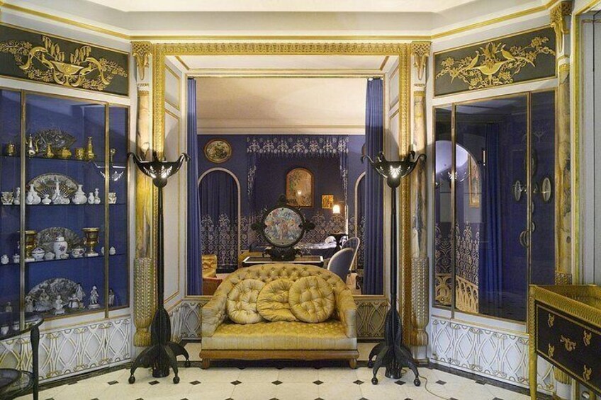 A luxurious room with a golden sofa, ornate decorations, and a blue and gold color scheme. 4