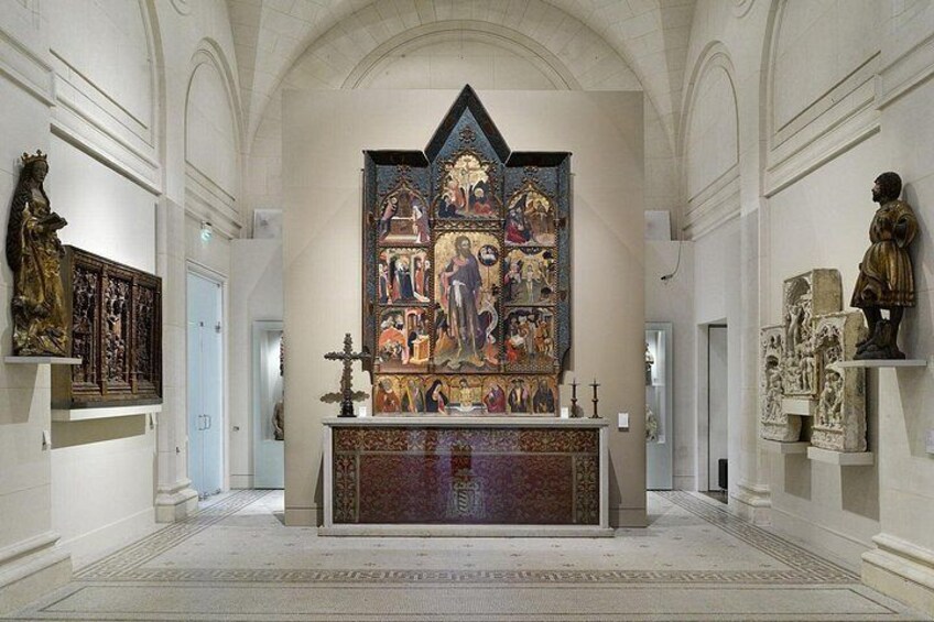 An interior with a large religious painting, a wooden altar, and statues. 3