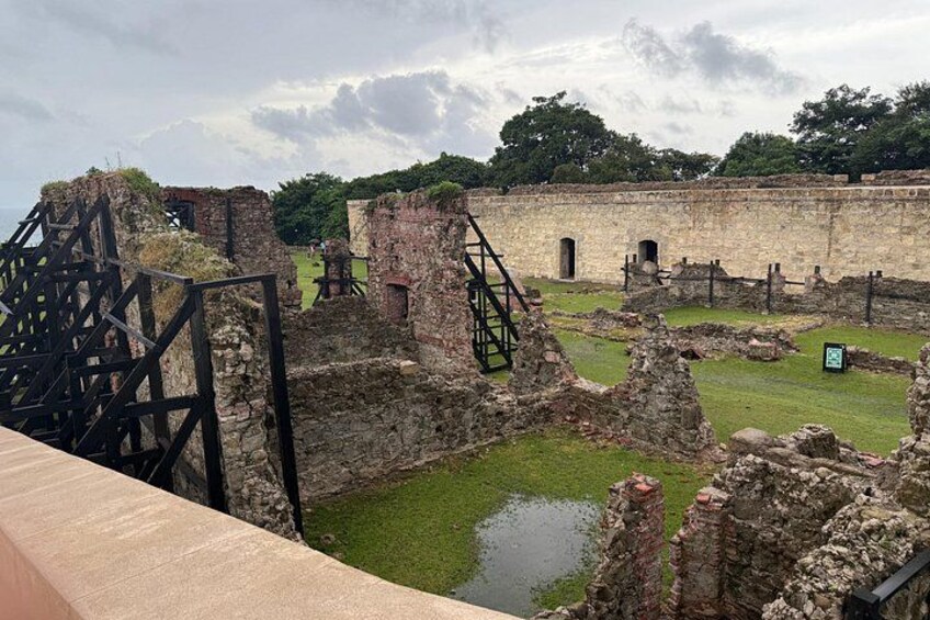 Ruinas antiguas con muros de piedra y una zona cubierta de césped. 2