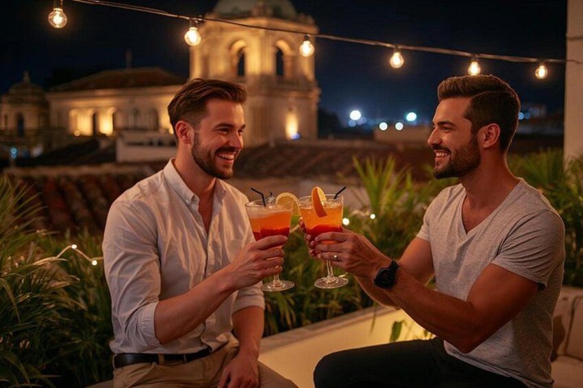 Two people toasting with drinks, a string of lights, and a building in the background. 2