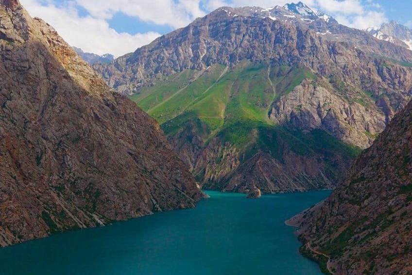 A mountainous landscape with a turquoise lake surrounded by rugged terrain. 4