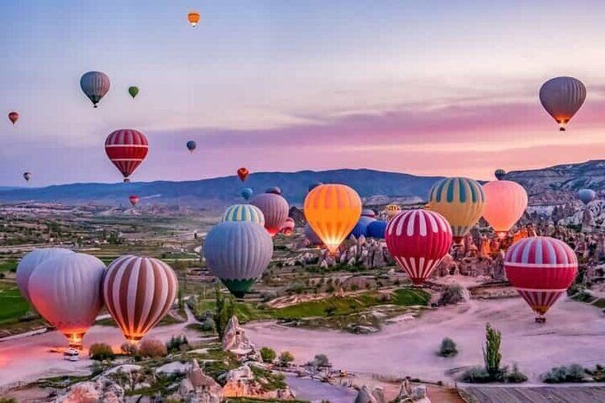 Un paisaje con numerosos globos aerostáticos de varios colores. 1