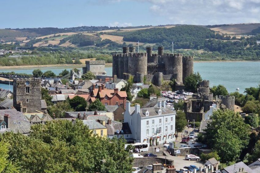 A historic castle surrounded by a town with a river in the background. 1