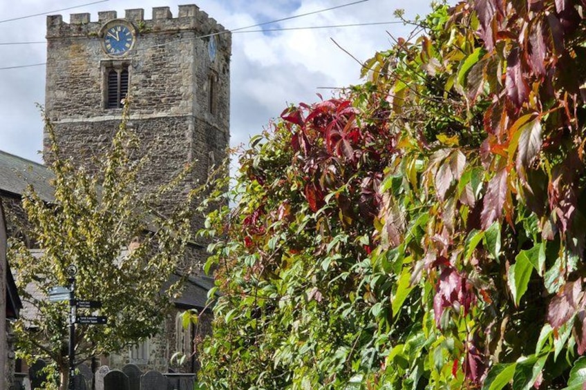 A stone tower with a clock, surrounded by autumn foliage. 2