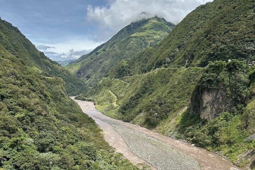 A river winding through a lush valley with steep hills on either side. 4