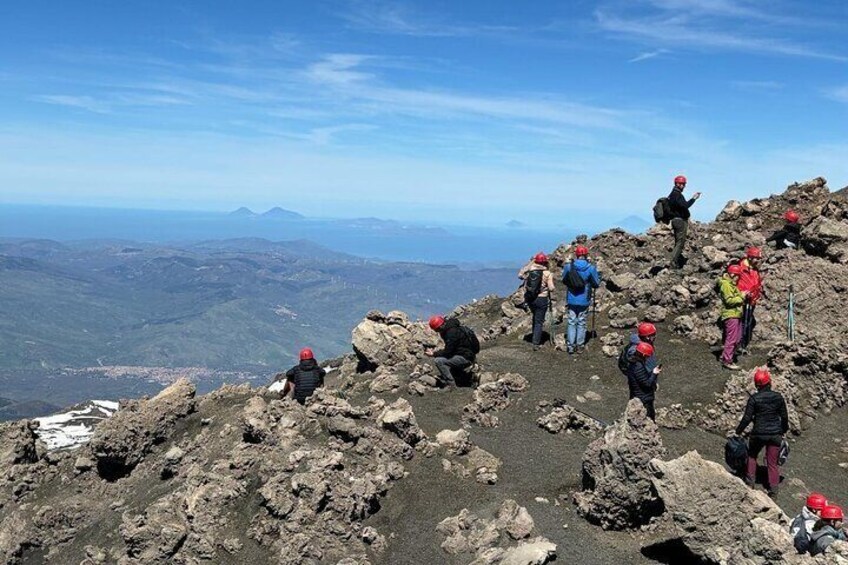 A group of hikers on a rocky mountain peak with a view of distant mountains. 5