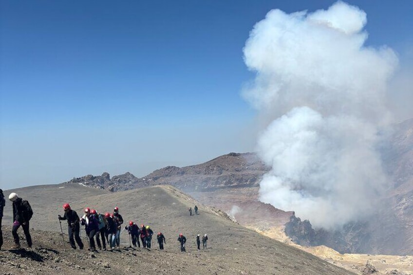 A group of hikers on a mountain trail with a steam vent. 4