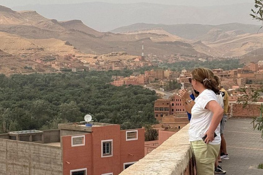 Una persona fotografiando un paisaje urbano con montañas al fondo. 5