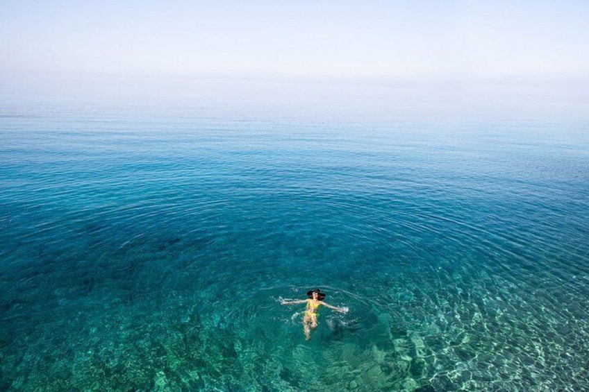 A person swimming in clear blue water. 2