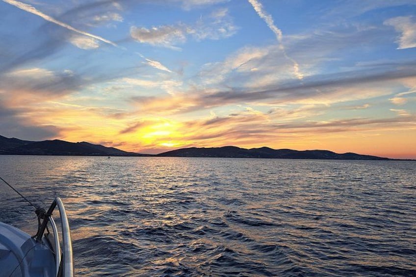 A sunset over a body of water with a boat in the foreground. 2