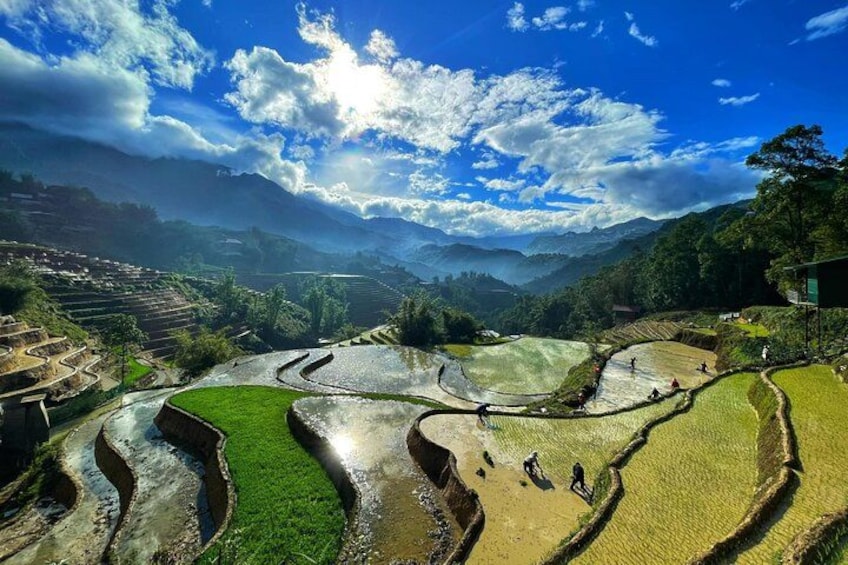 Terrazas de arrozales, un río y montañas distantes bajo un cielo parcialmente nublado. 3
