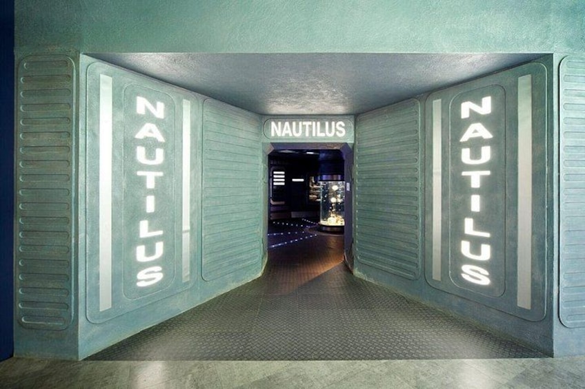 A corridor with 'NAUTILUS' signs on the walls and a sign above the door. 5