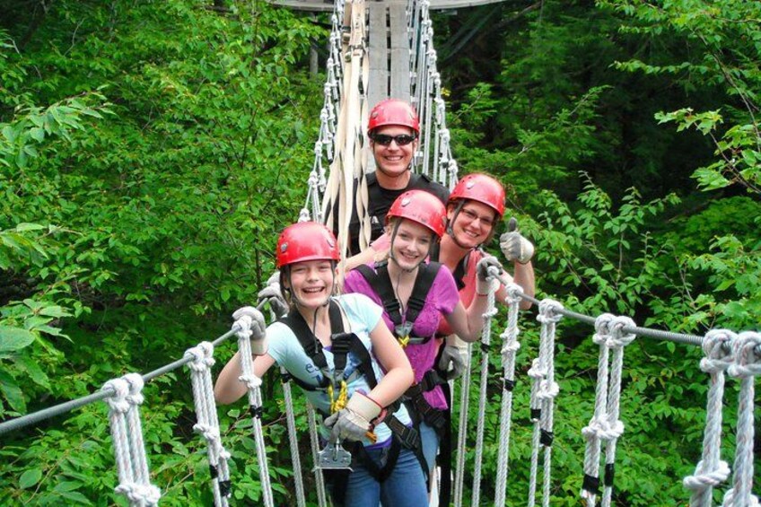People on a rope bridge in a forest. 1