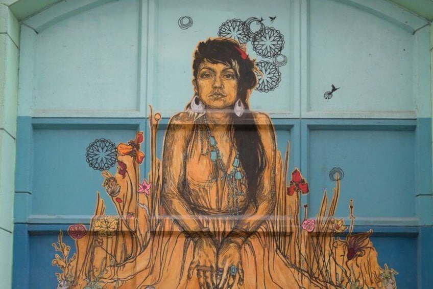 A mural with a central figure surrounded by floral and geometric patterns. 4