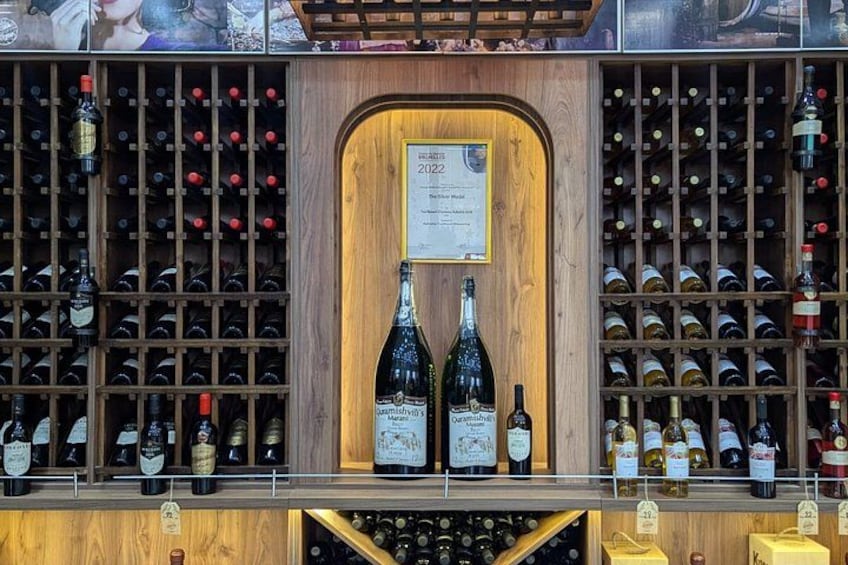A wine cellar with wooden racks and two prominent bottles in the center. 5