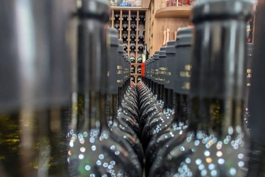 A wine cellar with rows of wine bottles and a wooden rack in the background. 2