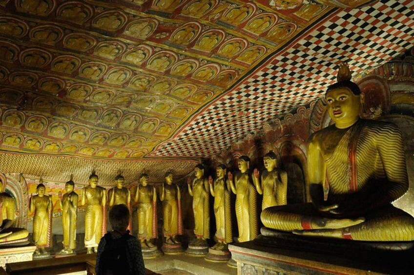 A temple interior with golden statues and a checkered ceiling. 2