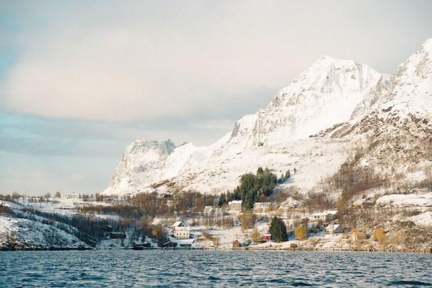 Ett snötäckt berg, en sjö och en liten by med några få byggnader. 4