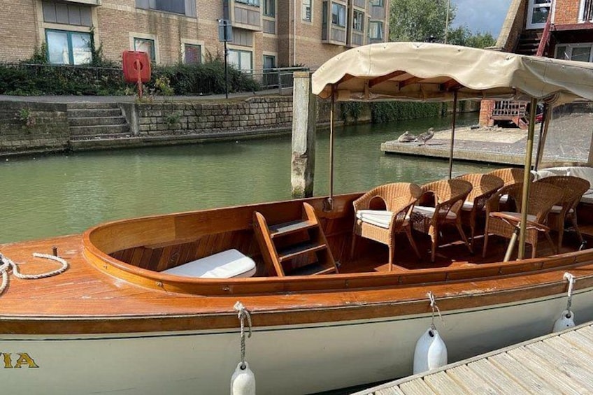 Un bateau en bois était amarré à un canal, et on pouvait y voir des chaises en osier et un auvent. 5