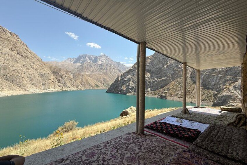 A covered outdoor area with a view of a lake and mountains. 3