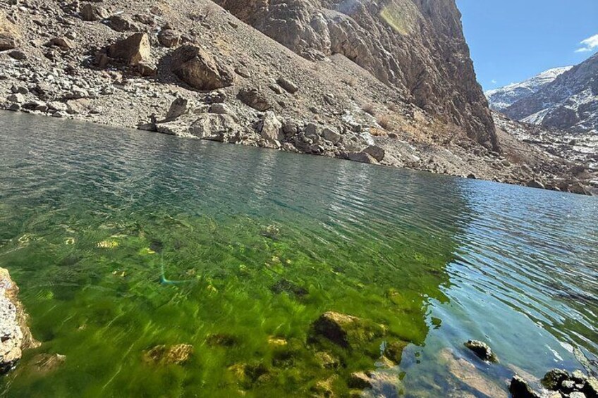 A clear mountain lake surrounded by rocky terrain. 5