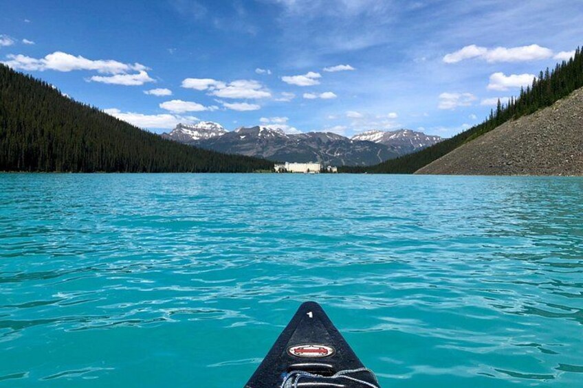 Un kayak su un lago turchese con montagne sullo sfondo. 3