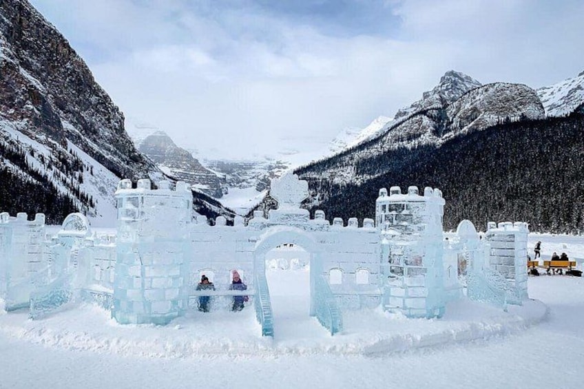 Un castello di ghiaccio in un paesaggio innevato, con montagne sullo sfondo. 2