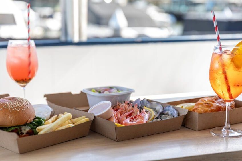 A table with food items including a burger, fries, seafood, and drinks. 4