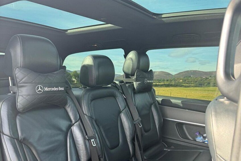 The interior of a Mercedes-Benz car with leather seats and a sunroof. 3