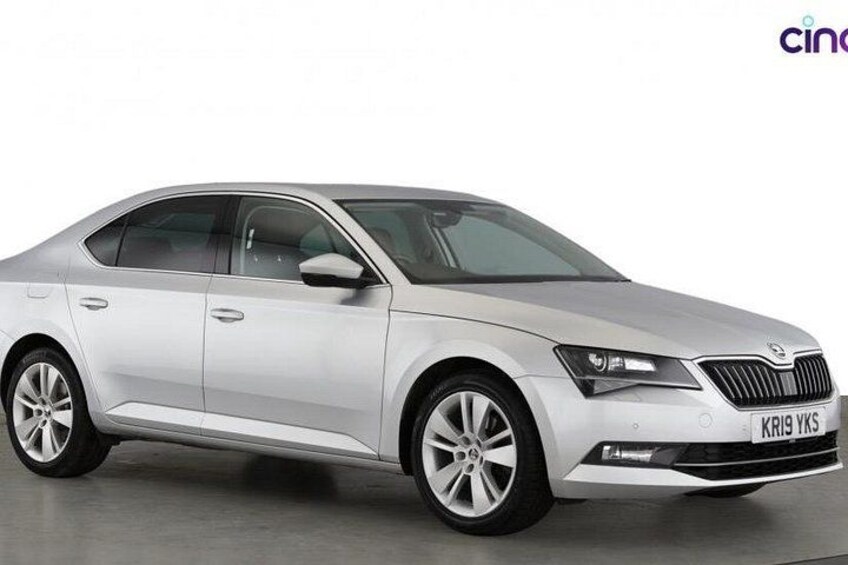 A silver sedan with a visible license plate, a modern design, and alloy wheels. 3
